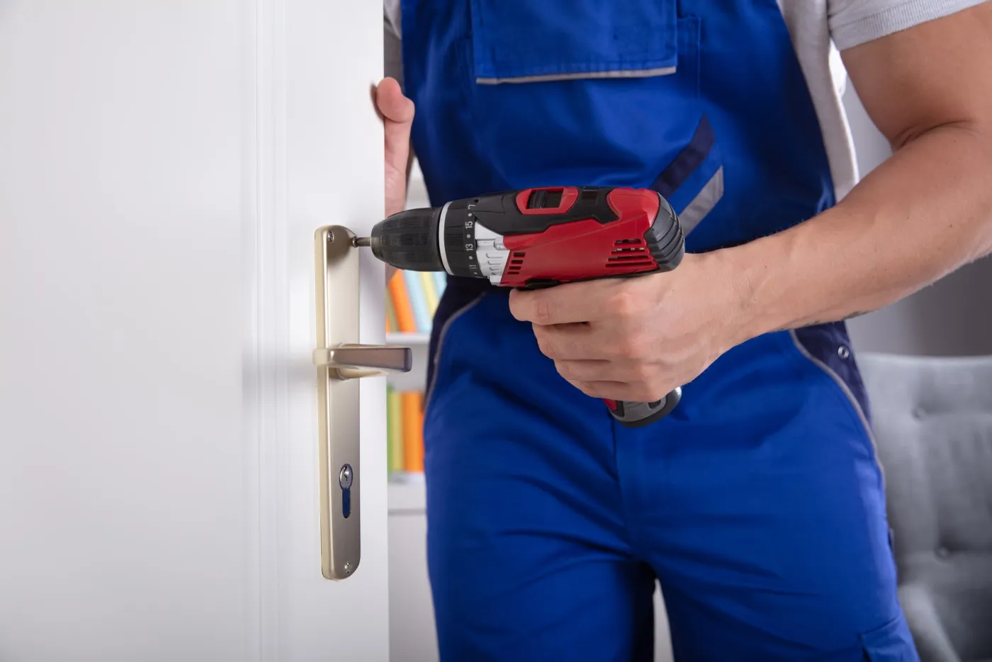 Serrurier perçant une têtière de serrure sur une porte dans l'Essonne